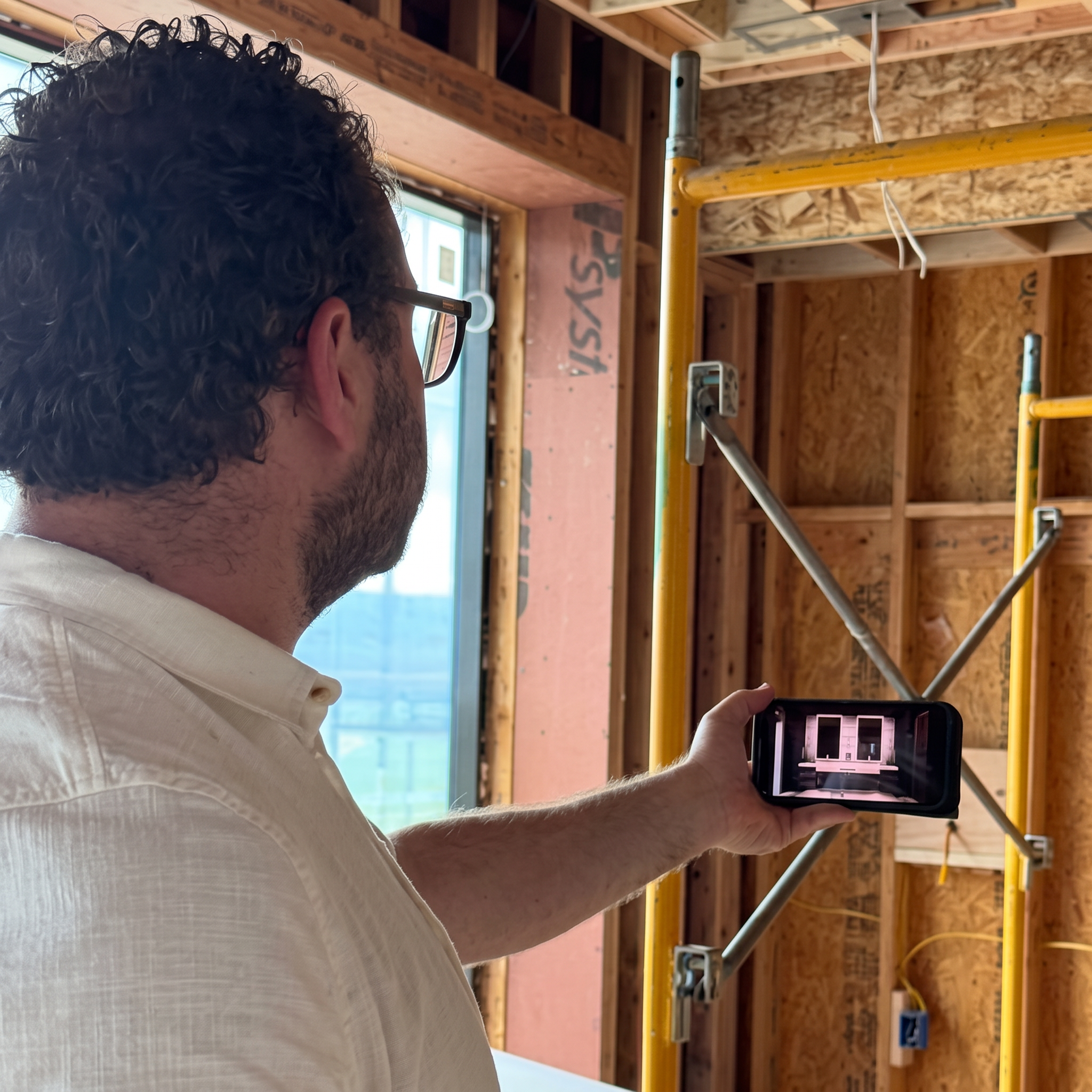 Derek Haughey comparing a digital design with the room under construction